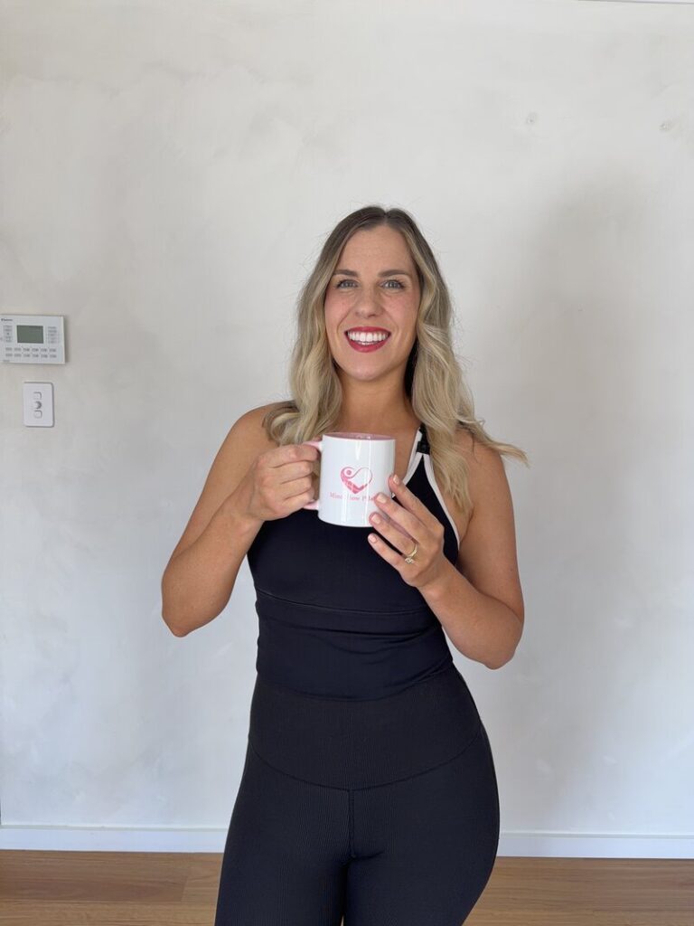 Pilates instructor holding a mug in a bright home studio