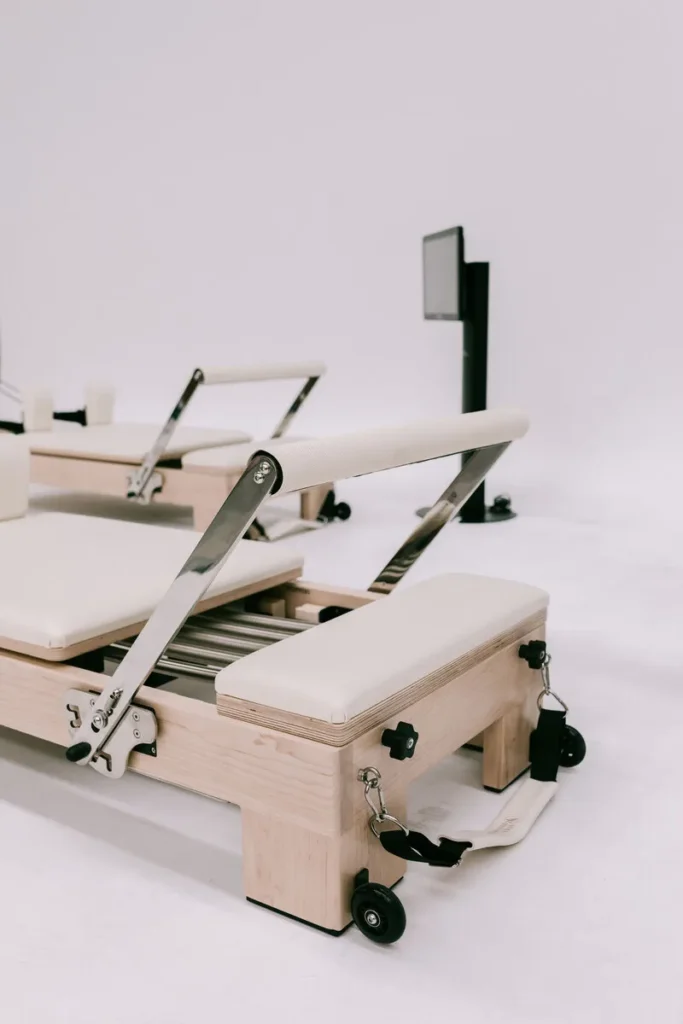 Modern Pilates reformer machine in a minimalist white studio