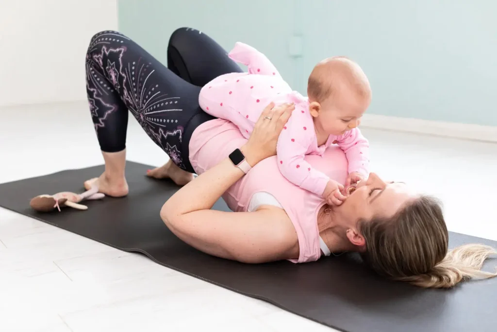 Mother and baby enjoying a mum and bub Pilates exercise together on a yoga mat